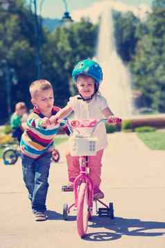 男孩女孩公园学习骑自行车