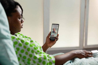 非洲美国年轻的病人持有智能手机讨论药物治疗治疗