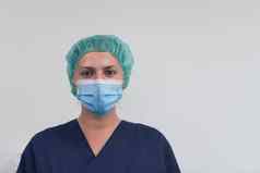 关闭女医生科学家医疗面具外科手术帽灰色背景调整面具