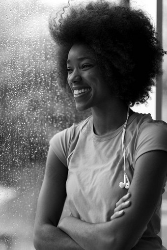 肖像年轻的非洲式发型美国女人健身房听音乐