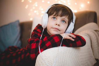 男孩耳机说谎沙发生活方式男孩听音乐