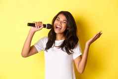 图像无忧无虑的非裔美国人女孩唱歌麦克风微笑快乐执行黄色的背景