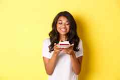 肖像美丽的非裔美国人女孩庆祝生日微笑快乐生日蛋糕蜡烛站黄色的背景