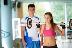 年轻的运动女人教练锻炼权重提升