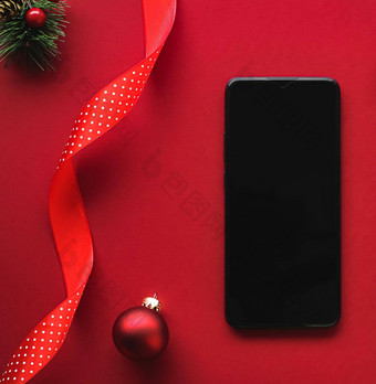 圣诞节电话应用程序假期消息概念智能手机空白黑色的屏幕圣诞节装饰红色的背景平躺模型设计