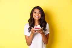 肖像美丽的非裔美国人女孩庆祝生日微笑快乐持有生日蛋糕蜡烛站黄色的背景