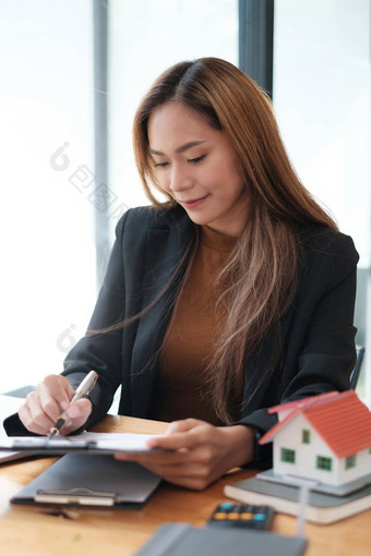 业务女人手持有笔移动PC工作预算账户文书工作账户储蓄钱保险概念