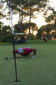高尔夫球球员吹球洞日落背景