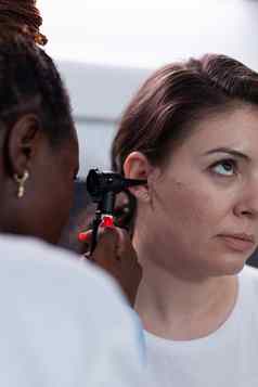 特写镜头非洲美国耳科医生医生分析女人病人耳朵