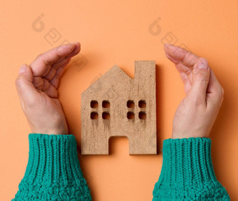 女手折叠木微型模型房子棕色（的）背景真正的房<strong>地产</strong>保险概念环境保护家庭<strong>幸福</strong>