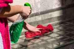 女人清洁玻璃表格红色的超细纤维地毯清洁喷雾器清洁服务概念做家务管家概念