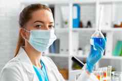 女人科学家实验室工人持有玻璃瓶化学液体