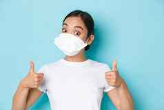 科维德社会距离冠状病毒流感大流行概念惊讶深刻的印象亚洲女孩白色t恤呼吸器显示竖起大拇指批准赞美好选择赞美