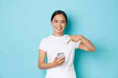 生活方式技术电子商务概念半身照漂亮的微笑亚洲女孩推荐应用程序购物网站移动电话在线订单指出手指智能手机