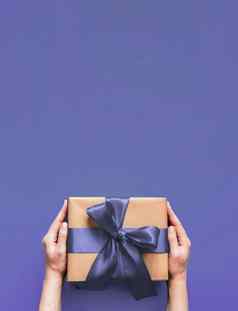 女手持有礼物盒子紫罗兰色的颜色