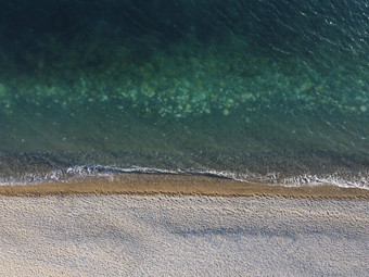 空中视图Azure海鹅卵石海滩小波玻璃清晰的水表面运动模糊自然夏天海洋海海滩背景假期假期旅行概念
