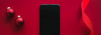 圣诞节电话应用程序假期消息概念智能手机空白黑色的屏幕圣诞节装饰红色的背景平躺模型设计