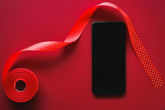 圣诞<strong>节</strong>电话应用程序假期消息概念智能<strong>手机</strong>空白黑色的屏幕圣诞<strong>节</strong>装饰红色的背景平躺模型设计