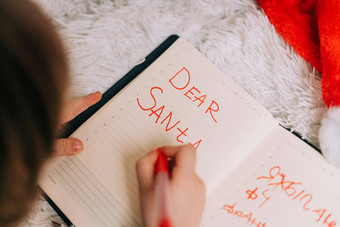 关闭手孩子男孩说谎沙发上写作信请注意垫亲爱的圣诞老人首页圣诞节假期孩子列表梦想圣诞节礼物快乐圣诞节快乐一年