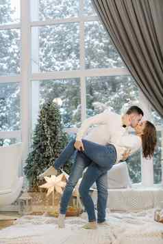 美丽的年轻的夫妇摆姿势摄影师一年工作室圣诞节树雪