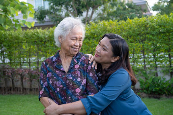 亚洲上了年纪的女人照顾者走快乐自然公园