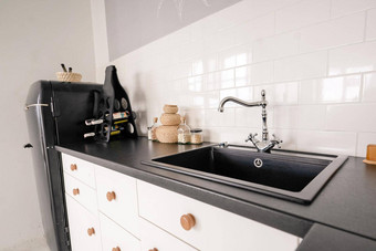 复古的风格黑色的水槽利用水光厨房厨房家具黑色的大理石工作台面厨房内阁白色瓷砖墙