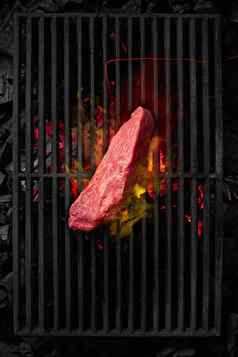 一块小牛肉里脊肉烹饪黑色的烧烤炉篦燃烧炭