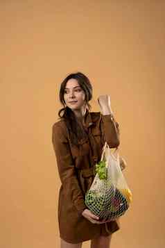 可重用的生态袋购物字符串购物袋水果蔬菜手年轻的女人浪费塑料免费的概念生态生活方式生态购物