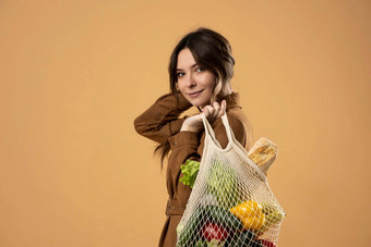 浪费概念年轻的布鲁内特女孩持有肩膀纺织生态袋食品杂货塑料免费的概念生态生活方式生态购物有意识的消费生态趋势