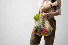 快乐女人持有可重用的棉花购物袋食品杂货面包绿色概念塑料浪费塑料免费的可持续发展的生活方式