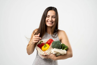 微笑浅黑肤色的女人女孩持有网<strong>购物</strong>袋蔬菜绿色塑料袋浪费塑料<strong>免费</strong>的生态友好的概念可持续发展的生活方式