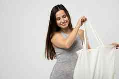 生态概念女人持有棉花杂货店袋蔬菜可重用的生态袋购物浪费概念生态友好的生活方式孤立的白色背景