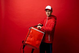 交付员工男人。红色的统一的热食物袋<strong>背包</strong>作品快递服务孤立的红色的背景工作室