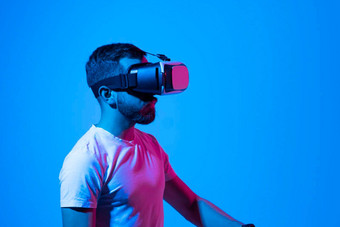 有胡子的年轻的男人。穿虚拟现实护目镜互动虚拟环境未来技术概念元宇宙