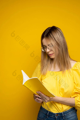美丽的聪明的年轻的女孩持有<strong>阅读</strong>书孤立的黄色的背景肖像有吸引力的女人黄色的上衣穿眼镜<strong>阅读</strong>书教育研究知识