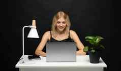 肖像漂亮的年轻的女人研究坐着表格灰色移动PC电脑笔记本微笑业务女人工作移动PC孤立的灰色背景