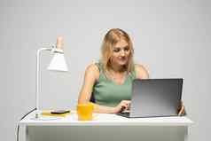 微笑业务女人工作移动PC孤立的灰色背景肖像漂亮的年轻的女人研究坐着表格灰色移动PC电脑笔记本