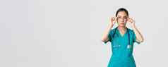 科维德医疗保健工人流感大流行概念自信严肃的表情确定亚洲女医生护士实习医生风云把眼镜准备好了转变紧急房间白色背景