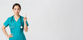科维德医疗保健工人流感大流行概念严肃的表情专业女亚洲医生实习医生风云医生摇晃手指禁止警告手势禁止
