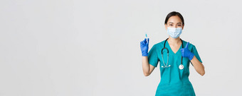 科维德冠状病毒疾病医疗保健工人概念愉快的微笑亚洲女医生医生医疗面具手套显示翘拇指持有注射器疫苗