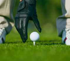 手黑色的皮革手套放置高尔夫球球木三通中间高尔夫球高尔夫球球三通准备好了拍摄特写镜头
