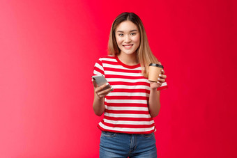 可爱的金发碧眼的亚洲大学女孩学生站午餐打破享受咖啡校园持有智能手机消息传递朋友等待女朋友公园<strong>订单外卖</strong>喝微笑广泛的红色的背景