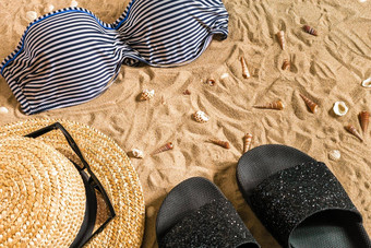 夏天<strong>比基尼</strong>配件时尚的海滩集海滩<strong>比基尼</strong>夏天装海沙子背景前视图概念
