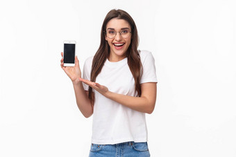 沟通技术生活方式概念肖像可爱的赶时髦的人女孩眼镜介绍应用程序移动应用程序推荐上传在线购物商店持有智能手机
