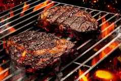 过程准备猪肉牛肉牛排肉烤金属可移植的烧烤烧烤烧烤明亮的燃烧的火桶木炭关闭