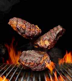 美味的烤猪肉牛肉牛排下降黑色的背景烧烤烧烤烧烤燃烧的火桶木炭烟关闭