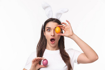 复活节假期春天概念特写镜头肖像逗乐热情的年轻的女人兔子耳朵站在相机打开口持有彩色的蛋眼睛手