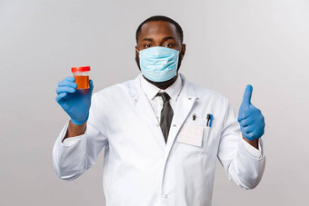 科维德流感大流行医疗保健概念非裔美国人医生制造口罩乳胶手套确保病人冠状病毒测试负好翘拇指显示<strong>尿液</strong>分析