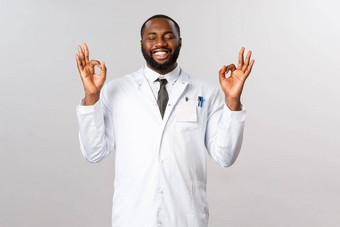 肖像松了一<strong>口气</strong>快乐非裔美国人英俊的医生白色外套关闭眼睛显示完美标志很高兴微笑科学家最后发现科维德疫苗实验室