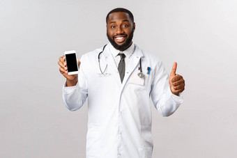 科维德流感大流行在线任命概念英俊的微笑非裔美国人医生推荐移动应用程序治疗病人调用医生咨询治疗咨询